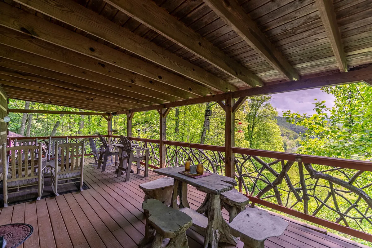A rustic wooden deck furnished with outdoor seating overlooks a beautiful natural landscape. The setting is ideal for group relaxation, socializing, or simply soaking in the views after a day of exploring.