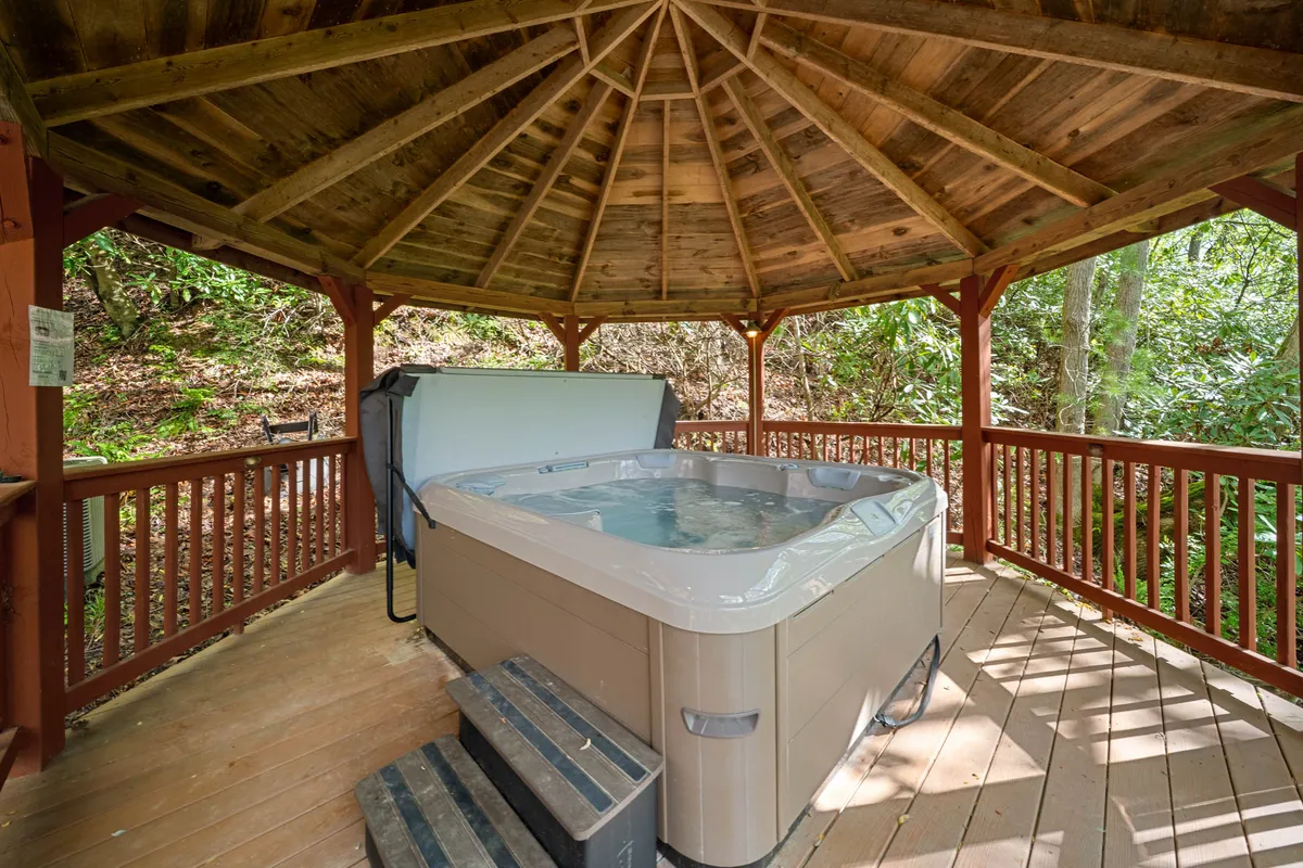 A cozy hot tub set into a wooden structure, surrounded by lush greenery, with the soft glow of sunset suggesting a peaceful retreat after a day of adventure.